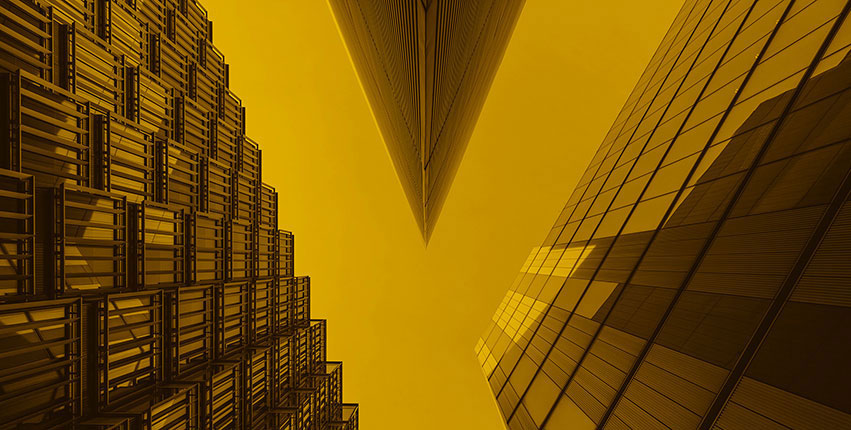 Upward view of modern glass skyscrapers converging toward the sky, warm golden-yellow duotone, bold and striking mood